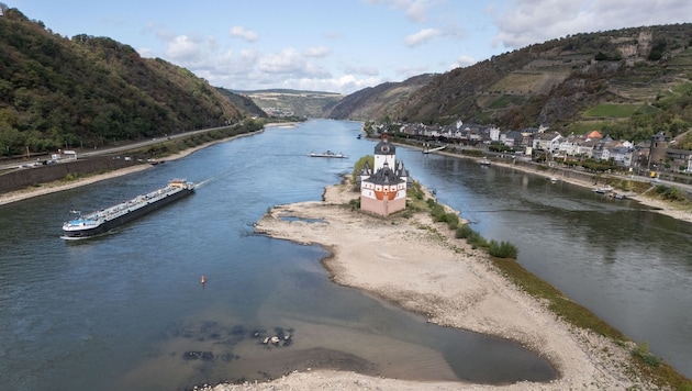 Ein Binnenschiff fährt an der Burg Pfalzgrafenstein vorbei über den Rhein bei Kaub – dieser ...