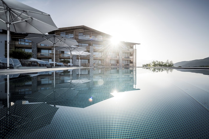 Vom großen Pool des Alpenresort Schwarz eröffnet sich ein schöner Blick auf die Tiroler ...