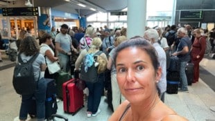 Lydia B. inmitten einer Warteschlange auf dem überfüllten Flughafen