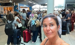 Lydia B. inmitten einer Warteschlange auf dem überfüllten Flughafen