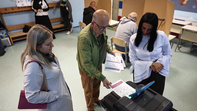 Einem älteren Herrn in Sarajewo wird bei der Wahl an der elektronischen Wahlurne geholfen.