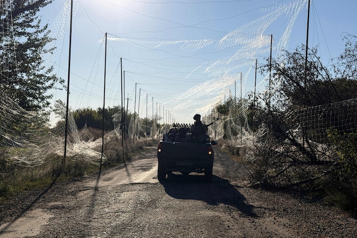 Ein ukrainischer Soldat fährt in der Region Dnipropetrowsk umgeben von Anti-Drohnen-Netzen auf ...