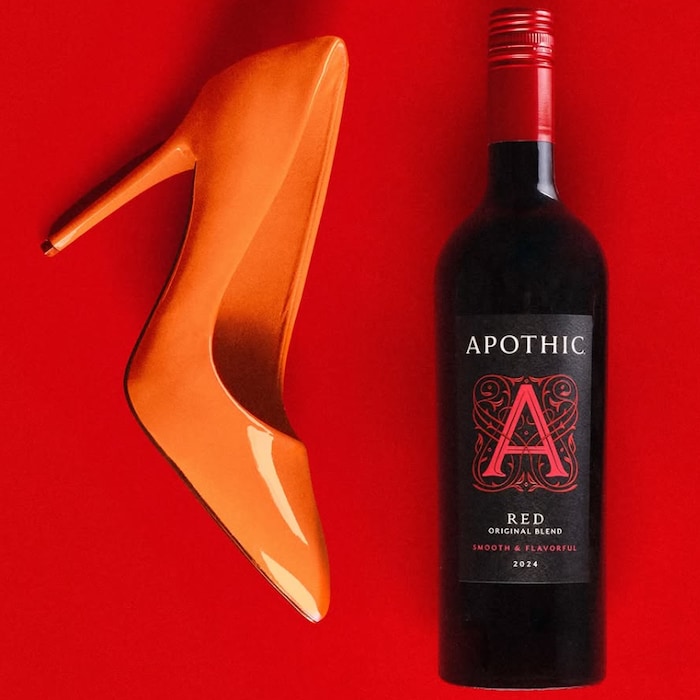 Das fünfte Bild: Ein orangener Schuh neben einer Flasche Wein.