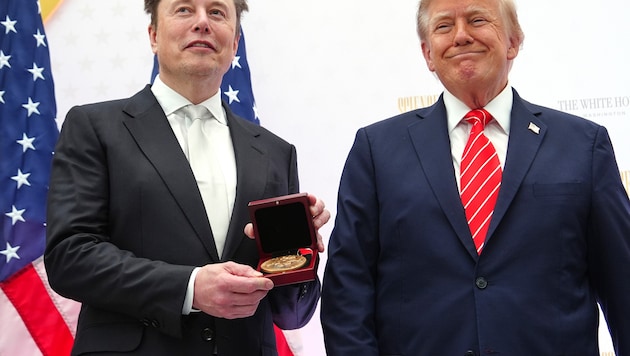 Musk zeigt neben Trump seine National Medal of Science in die Kameras.