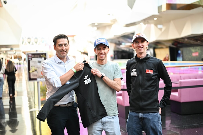 ÖSV-Sportdirektor Mario Stecher half Stefan Kraft (M.) ins 4F-Outfit