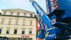 Ein riesiger Schwerlastkran hebt die Einzelteile über das Bankgebäude in den Innenhof