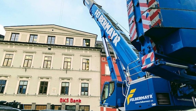Ein riesiger Schwerlastkran hebt die Einzelteile über das Bankgebäude in den Innenhof