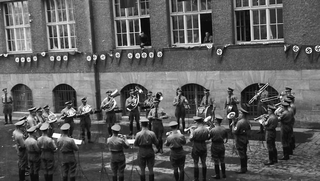 Die „Wiltener“ in SA-Uniform vor dem ehemaligen Gauhaus. Kapellmeister Sepp Tanzer dirigiert in ...