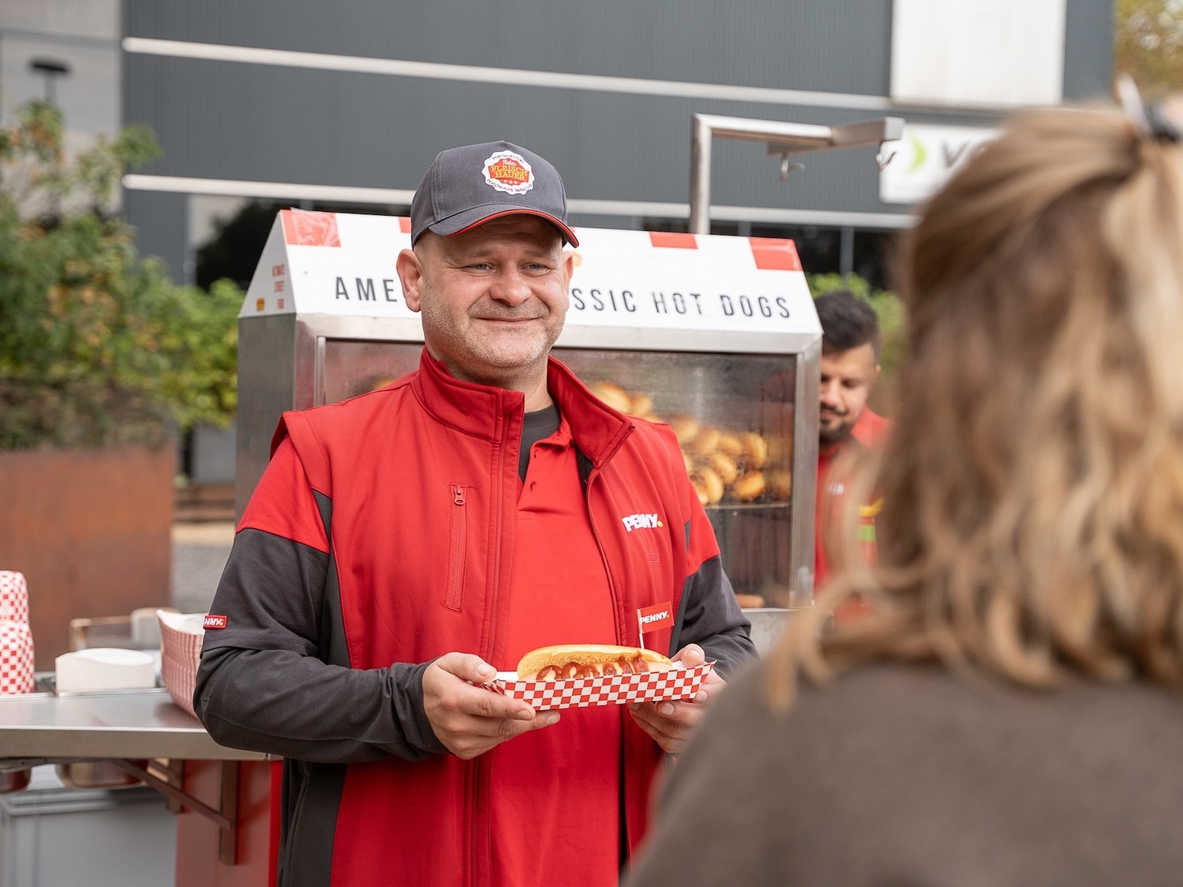 Das PENNY Team versorgt die Passant:innen mit frischen Hotdogs.