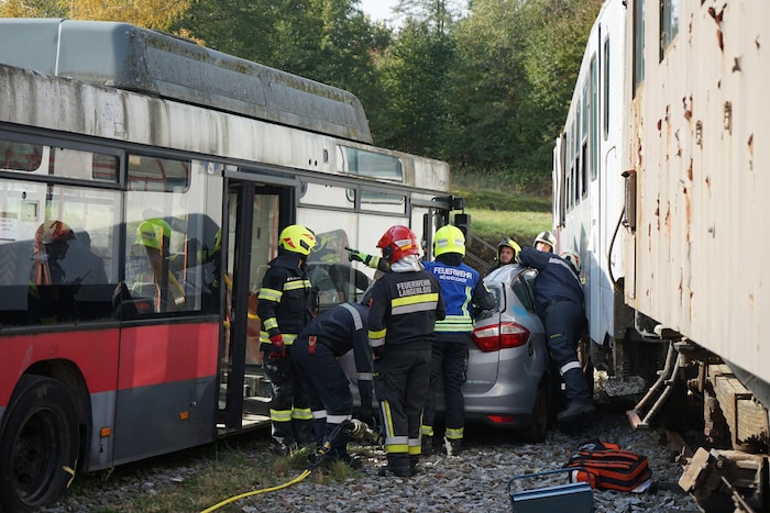 Zwischen Bus und Eisenbahnwaggon war ein Pkw eingeklemmt. Die Einsatzkräfte mussten die Insassen ...