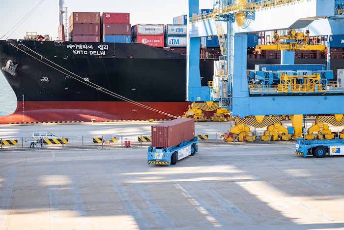 86 autonome Fahrzeuge transportieren Container am Hafen.