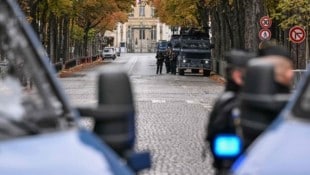 Französische Gendarmen stehen neben gepanzerten Fahrzeugen auf einer abgesperrten Straße in der ...