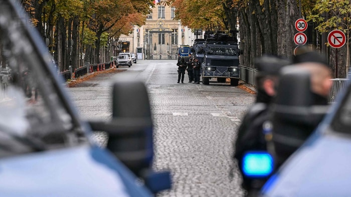 Französische Gendarmen stehen neben gepanzerten Fahrzeugen auf einer abgesperrten Straße in der ...