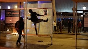 Demonstrierende schlagen eine Busstation in Barcelona kaputt.