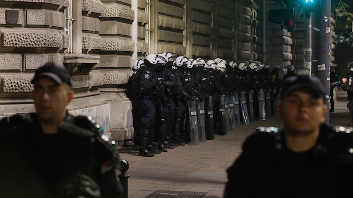 Kurz bevor die Wahllokale schließen, blockieren serbische Bereitschaftspolizisten eine Straße in ...