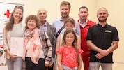 Irene (li.) und Maria Steinberger mit ihrer Familie, Rotkreuz-Bezirksstellenleiter Patrick ...