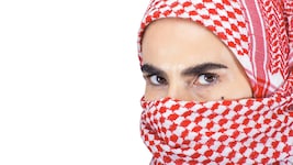Mit solch einem roten Tuch, als „Kufiya“ bekannt, hat die Frau ihr Gesicht verhüllt ...