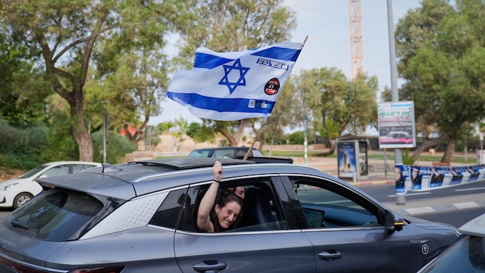 Eine Frau lässt am Wahltag die israelische Flagge aus dem Auto wehen.