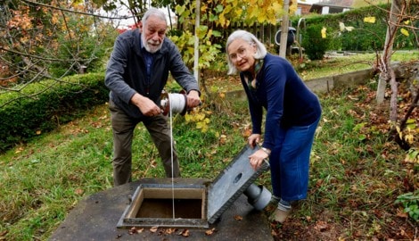 Gerhard und Johanna Krajicek messen den Pegelstand bei ihrem Hausbrunnen.