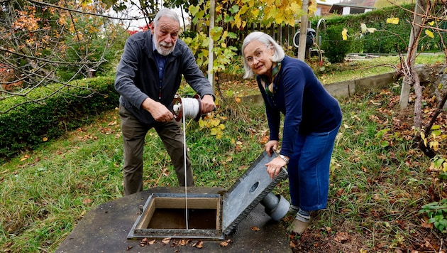 Gerhard und Johanna Krajicek messen den Pegelstand bei ihrem Hausbrunnen.
