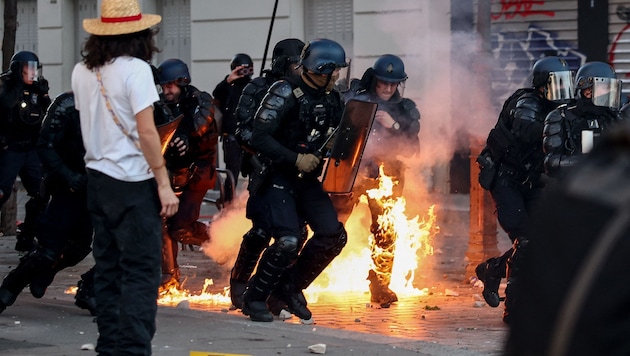 A police officer’s legs are on fire during the Halloween demonstration in Paris.