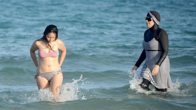 Links ein klassischer Bikini, rechts ein Burkini (Bild: APA/AFP/Fethi Belaid (Symbolbild))
