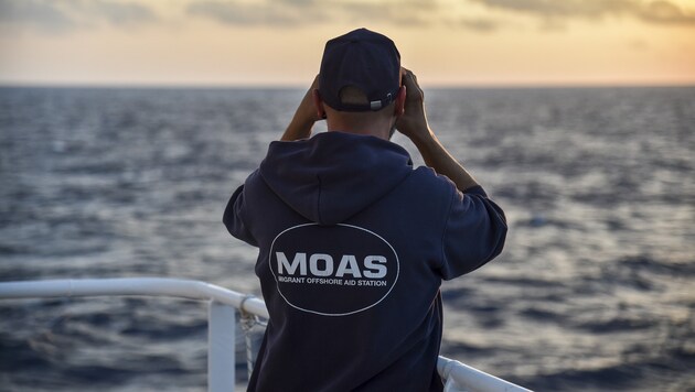 Ein Mitglied der NGO MOAS hält Ausschau nach Bootsflüchtlingen. (Bild: AFP)