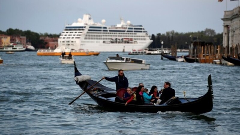 Eine Gondel am Canale Grande in Venedig, im Hintergrund ein Kreuzfahrtschiff (Bild: AFP)