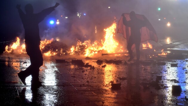 Vermummte Randalierer legten Feuer und gingen ohne Skrupel gegen Polizisten vor. (Bild: AFP)