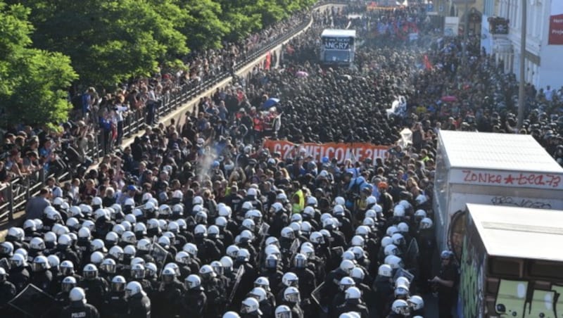 Der Demonstrationszug wird von einem massiven Aufgebot an Polizisten begleitet. (Bild: AFP/dpa)