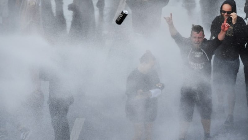 Diese Demonstranten trotzen dem Wasser. (Bild: AFP)