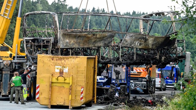 Die komplett ausgebrannten Überreste des Busses werden mit einem Kran geborgen. (Bild: ASSOCIATED PRESS)
