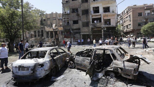 Völlig ausgebrannte Autowracks am Explosionsort (Bild: AFP)