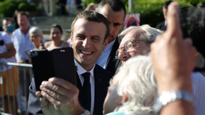 Fans machen ein Selfie mit Präsident Macron. (Bild: AP)