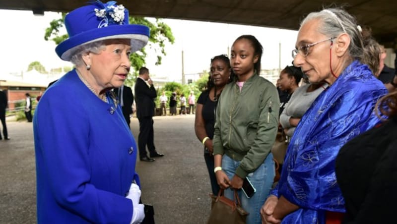 Königin Elizabeth II. spricht mit obdachlos gewordenen Menschen in einer Notunterkunft in London. (Bild: AP)