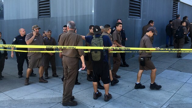 Angestellte der UPS-Zentrale werden von der Polizei in Sicherheit gebracht. (Bild: AP)
