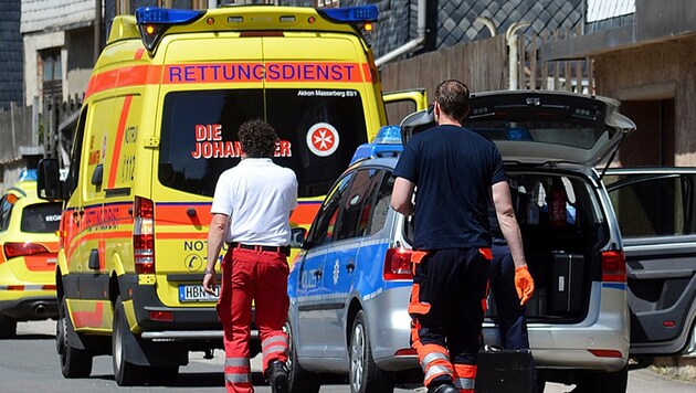 Rettungsdienste und Polizisten vor der Wohnung in Thüringen, wo sich das Blutbad ereignet hat. (Bild: dpa)
