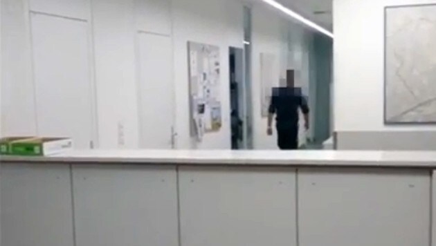 Der Beamte zieht sich in ein Hinterzimmer zurück. (Bild: YouTube.com/Falter)