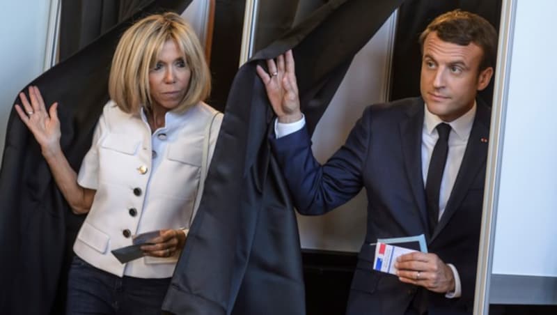 Emmanuel Macron und seine Gattin Brigitte in der Wahlkabine (Bild: AP)