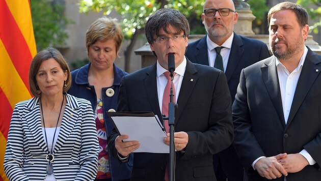 Carles Puigdemont (Bildmitte) bei der Ankündigung des Referendums (Bild: AFP/Lluis Gene)