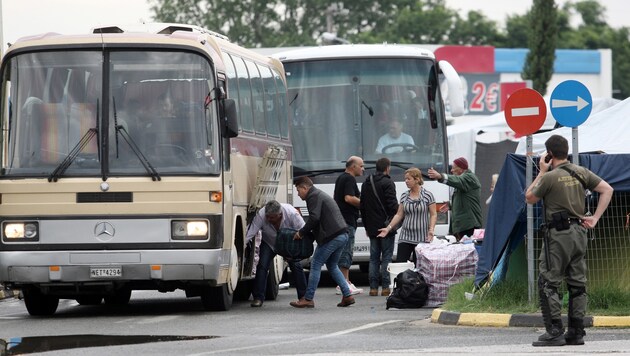Flüchtlinge laden ihr Gepäck in Busse, bevor es aus Griechenland nach Westeuropa geht. (Bild: AFP)