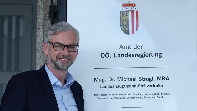 LH-Vize Michael Strugl stolz vor seinem jungen Türschild in Linz mit noch mehr Ressortbereichen. (Bild: Land OÖ / Sabrina Liedl)