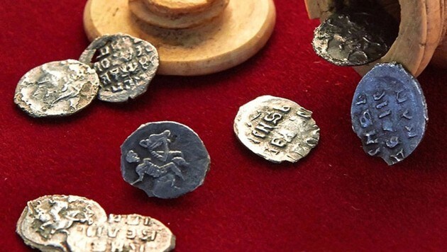 Acht der zehn in der Schachfigur (am oberen Bildrand) gefundenen Münzen (Bild: Stadtverwaltung Moskau)