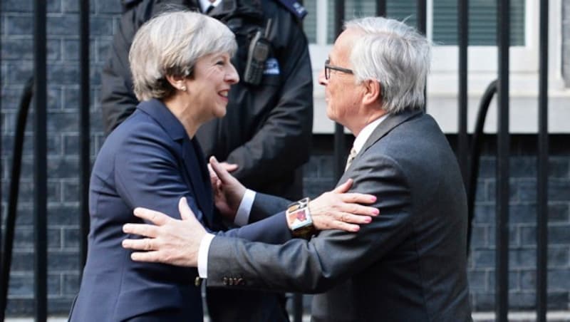 Theresa May und Jean-Claude Juncker umarmen sich für die Kameras recht herzlich ... (Bild: AP)