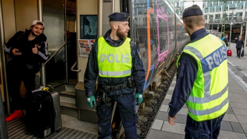 Polizisten kontrollieren einen Zug auf der Grenzbrücke zwischen Schweden und Dänemark. (Bild: AFP)