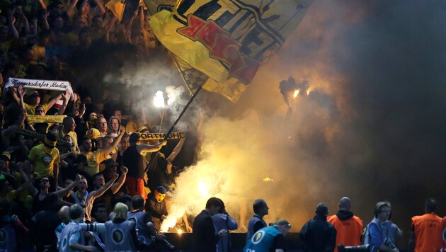 Bengalische Feuer sind bei Fußballfangruppen beliebt (im Bild Dortmund-Anhänger) (Bild: AP (Symbolbild))