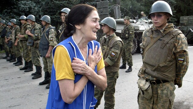 Verzweifelte Angehörige 2004 in Beslan am von Soldaten abgeriegelten Schulareal (Bild: AFP)
