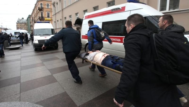Rettungskräfte eilen mit einem Verletzten zu einem Krankenwagen. (Bild: AFP)