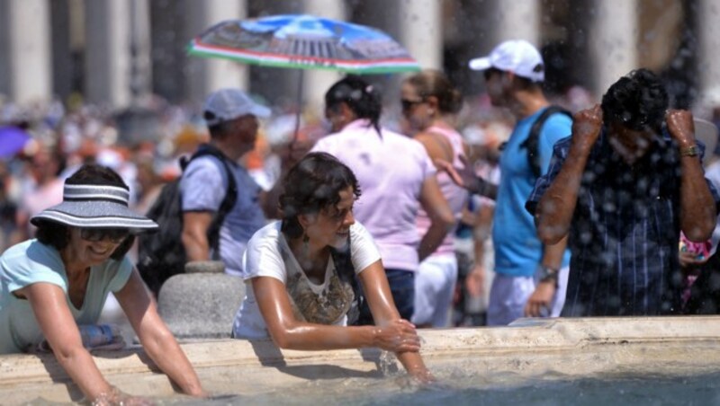 Touristen erfrischen sich an einem Brunnen am Petersplatz in Rom. (Bild: AFP)
