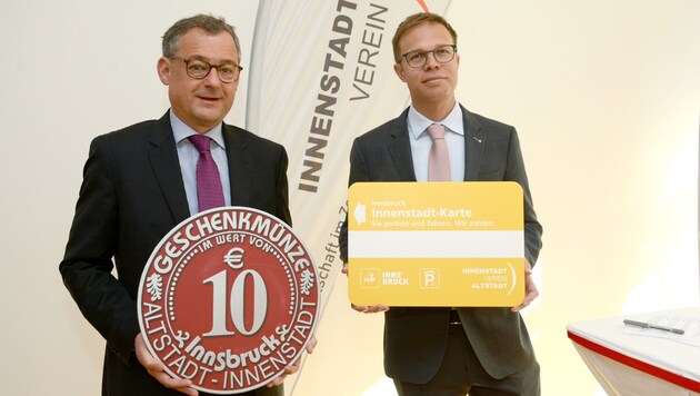 Obmann Thomas Hudovernik (li.) und seine Vize Ulrich Miller mit Innenstadtkarte und Geschenksmünze. (Bild: FISCHER ANDREAS)